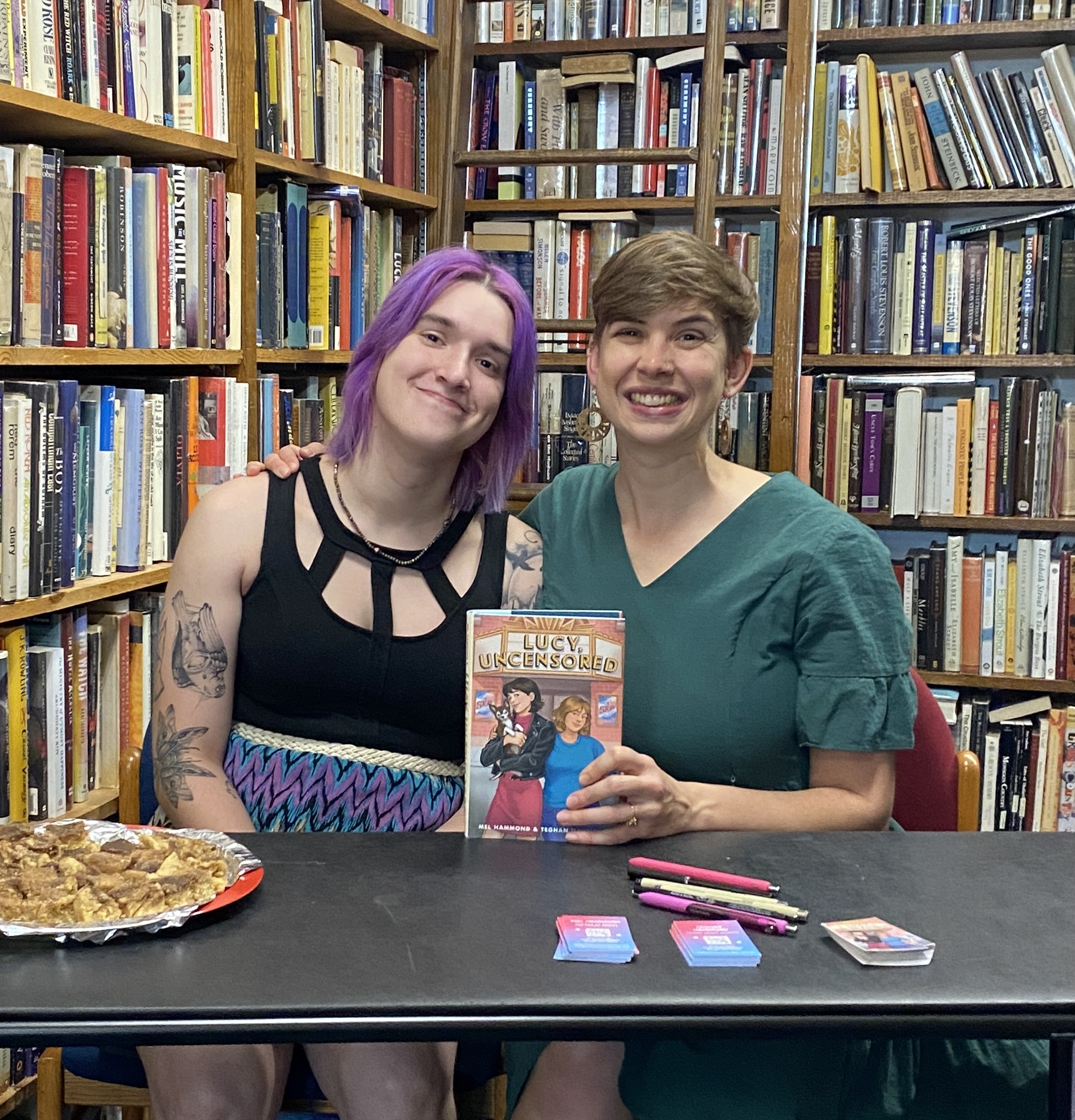 Mel and Teghan holding their book at a bookshop